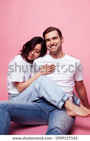 young cheerful caucasian couple together having fun on pink background, guy ang girl modern relationship, lifestyle people concept