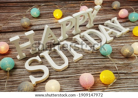 Happy Sunday alphabet letter with LED cotton balls on wooden background