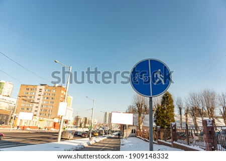 A sign that divides the path for pedestrians and bicyclists. Round blue sign Pedestrian and Bicycle path close-up