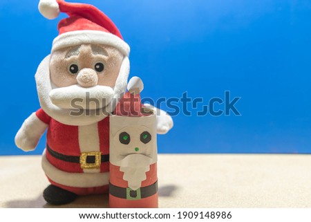 Santa Claus doll. Blue Christmas background. Reasons for Christmas Day. Year-end party decoration. Catholic feast.