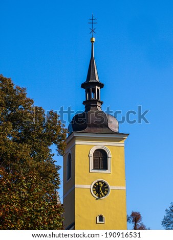 Yellow tower of village church in Lounovice (Czech Republic)