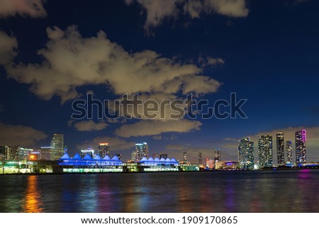 Miami night downtown, city Florida. Miami city skyline panorama with urban skyscrapers over sea with reflection