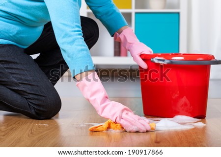 Elderly woman kneeling, doing floor cleaning at home Royalty-Free Stock Photo #190917866
