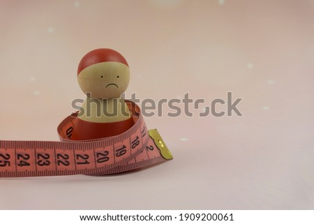 Unhappy plum woman figure with tape measure around her body.