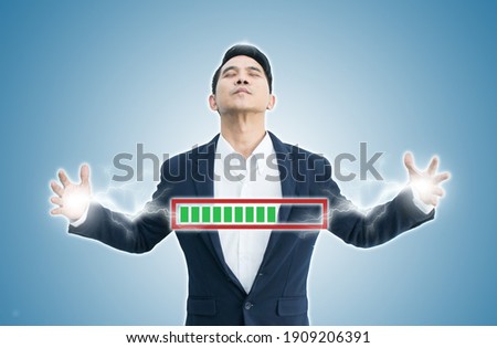 Asian business man standing with charging energy