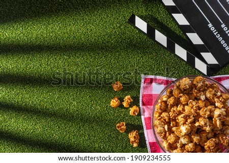 Movie clapperboard, popcorn boxes , 3d glasses on the grass background. Movie night concept. Flat lay composition. Cinematic photo for blogs or design. View from above.