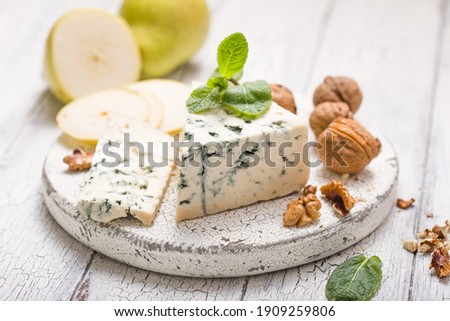 Segment of blue mould cheese - Gorgonzola with pear and walnuts on wooden board.  Top view Royalty-Free Stock Photo #1909259806