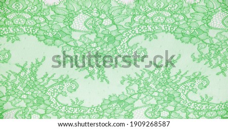 lace fabric. bird feather. green on a white background. Delicately crafted from yarn or thread, lace fabrics have historically embodied class and beauty since their inception in the 16th century.