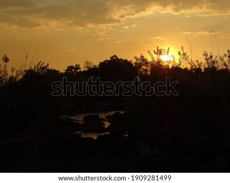 sunset at the popa falls with grasses in the foreground in namibia