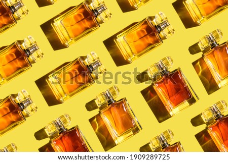 A pattern of woman perfume on the illuminating yellow background, top view, flat lay. Trend color of the year 2021. Mockup of fragrance perfume bottles Royalty-Free Stock Photo #1909289725
