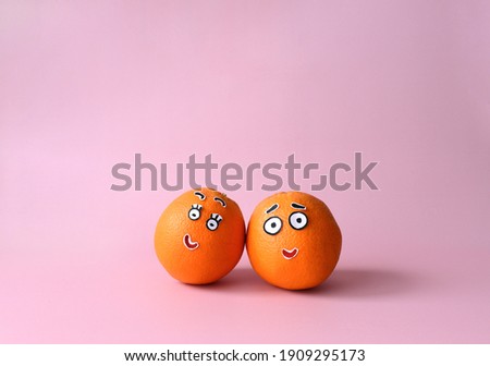 
Two funny oranges with eyes. Couples in love. Pink background.