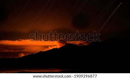 photo of a fire burning in the mountains at night