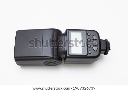 Wireless speedlite flash for photography on white background. It has a display screen and seven gray buttons for different functions.