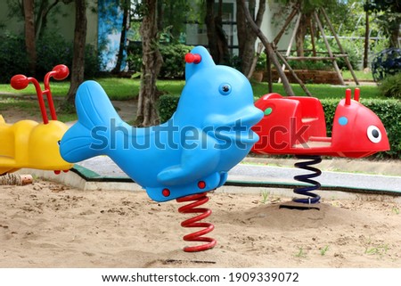 Children's playground with animal spring toy riders in the garden background Royalty-Free Stock Photo #1909339072