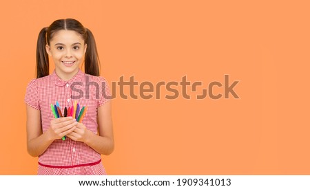 happy child girl hold colorful pens or markers for studying, copy space, back to school.