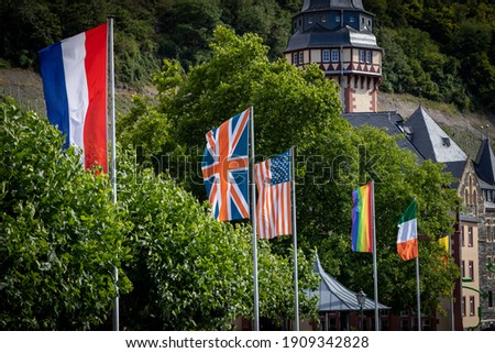 Image of rainbow LGBT flags hanging in the row of national flags. Human rights symbols.