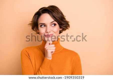 Portrait of young attractive beautiful thoughtful happy girl thinking look copyspace isolated on beige color background Royalty-Free Stock Photo #1909350319