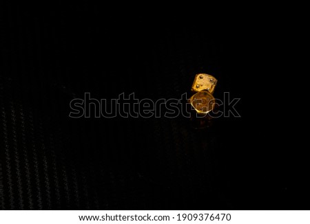 Golden dice gambling and black dice disorganized over black background