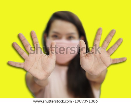 Concept picture of young woman wear mask to protect herself from virus on yellow background
