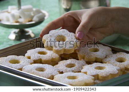 close up of female hand taking pastry biscuit from a box on the table