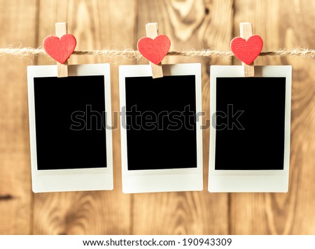 Photo paper attach to rope with clothes pins on wooden background 