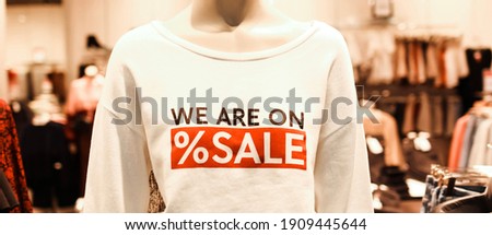 T-shirt with advertising text ‘we are on sale’ on mannequins in a clothing store. Retail shopping. Banner.