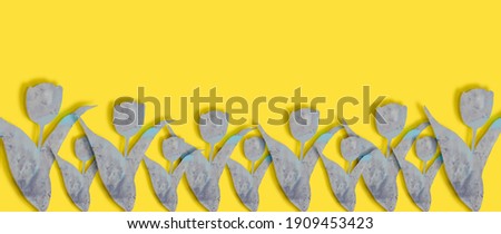 Gray flowers on yellow background. Abstract flower silhouette. Tulip with stone texture.