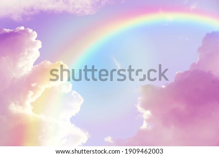 Amazing sky with rainbow and fluffy clouds, toned in unicorn colors Royalty-Free Stock Photo #1909462003