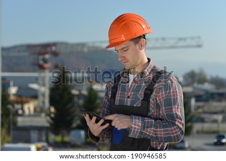 Engineer at construction site, an image from the construction industry of a worker with a computer tablet. 