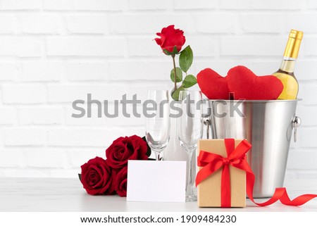 Valentine's Day celebration with wine, gift and rose bouquet for holiday greeting.