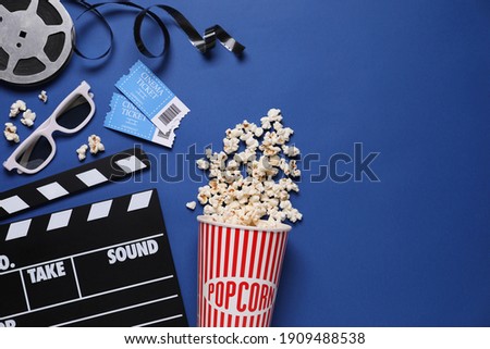 Flat lay composition with clapperboard, cinema tickets and 3d glasses on blue background, space for text