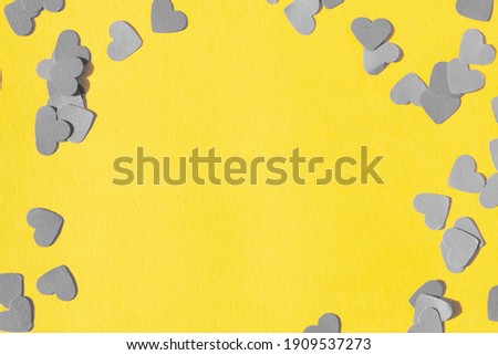 heart shape confetti on a yellow background for valentines day 