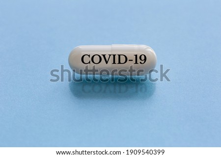 White capsule with text isolated on a blue background. COVID-19 vaccination concept and other infection diseases. nCoV 2019 outbreak - China.