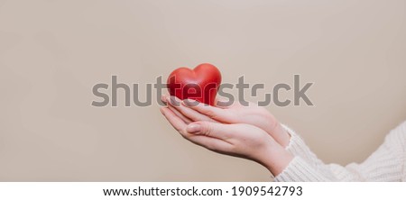 Close up of woman hands holding giving red heart shape. People, love, charity, health and family concept. Royalty-Free Stock Photo #1909542793