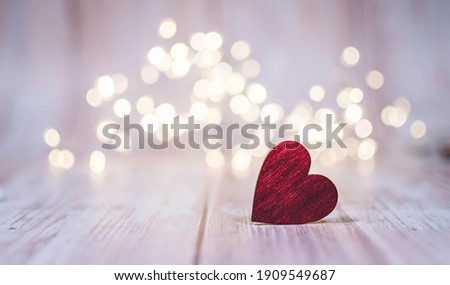 Close up of red heart on wooden table against defocused bokeh light background. Love, valentine's day concept.