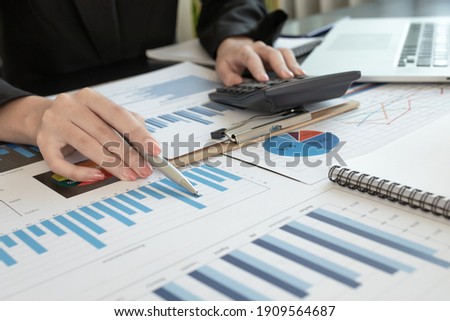 Asian businesswoman hands hold documents with financial statistic stock photo,discussion and analysis data the charts and graphs. Finance concept
