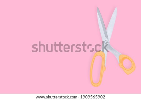 Barber scissors against red background background.