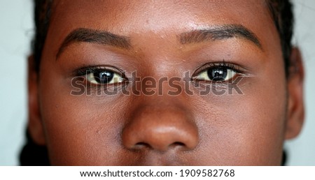 African girl eyes staring camera. Macro close-up Mixed race young woman eye, casual real person