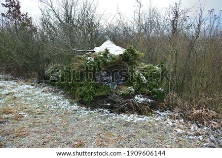 Camouflage shelter in the bushes at the edge of the forest for wildlife photographers