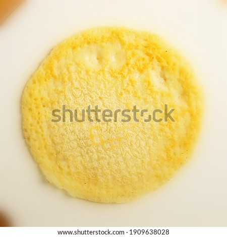 Single pancake made of flour with a sharp center in a frame and blurred cuts made from fresh flour prepared for Shrovetide.
