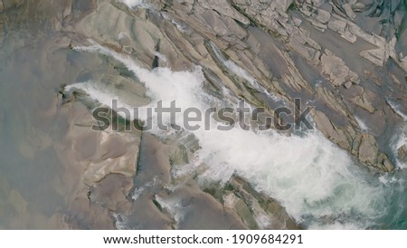 Waterfall in the Winter. Rapid Flow of Water from a Mountain Creek and Stone Rapids with Snow. The river Prut in Ukrainian Carpathians in Yaremche city.Melting ice and snow on the river in the forest.