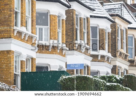 To Let sign displayed outside terrace houses during snowfall around Crouch End area in London