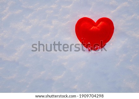 Red heart in snow. Valentine's day background. Copy space.
