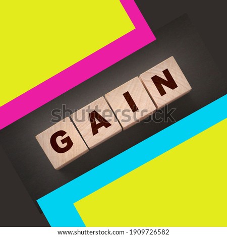 inscription gain on wooden cubes with letters on black background. Business profit concept.