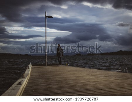 lone person at the pier in stormy weather
