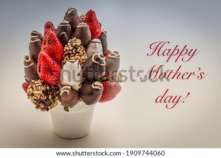 Happy Mother's day greeting card with red lettering; A bunch of edible flowers, arrangement of chocolate dipped strawberries isolated on white background