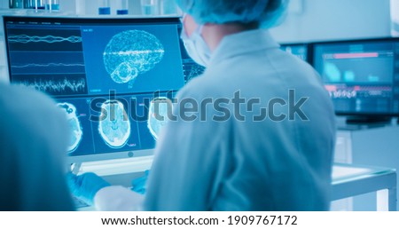 Scientists studying brainwave scanning models and DNA sequencesl. Royalty-Free Stock Photo #1909767172