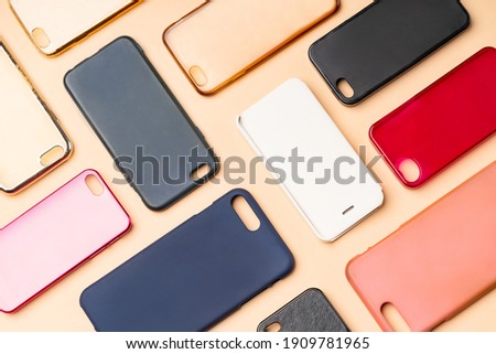Pile of multicolored plastic back covers for mobile phone. Choice of smart phone protector accessories on neutral background. A lot of silicone phone backs or skins next to each other Royalty-Free Stock Photo #1909781965