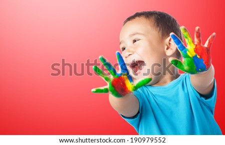 portrait of cute kid having fun with hands paint