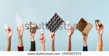 Separate collection of garbage. Human hands holding plastic, glass, metal, paper, lightbulb stuff for recycle. Eco friendly people. Human's hand holds recyclable waste on blue background. Zero waste Royalty-Free Stock Photo #1909807591